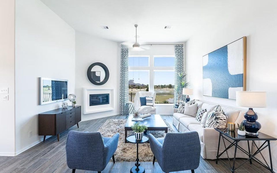 Bright and welcoming family room offering a beautiful first impression, featuring high ceilings, abundant natural light, and woodlike vinyl plank flooring throughout the main living area, with an open layout that flows effortlessly into the dining area and kitchen, a wonderful space for everyday living and relaxed gatherings. **Photos are representative only and may vary as built.**