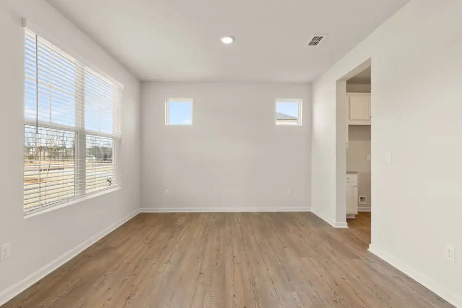A room with a wood floor and windows. A room with a wood floor and windows.