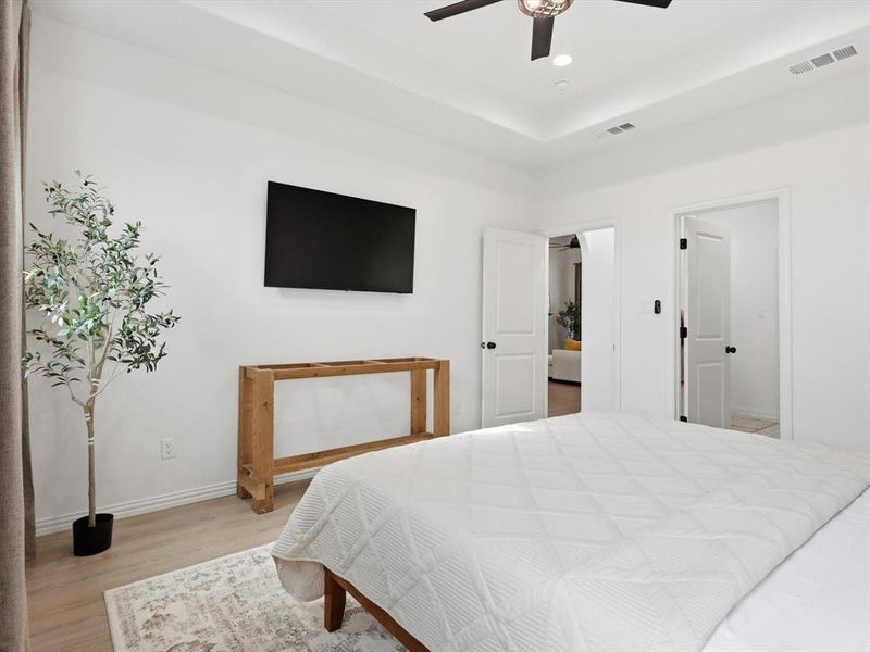 Primary bedroom is a relaxing oasis with large windows and coffered ceilings.