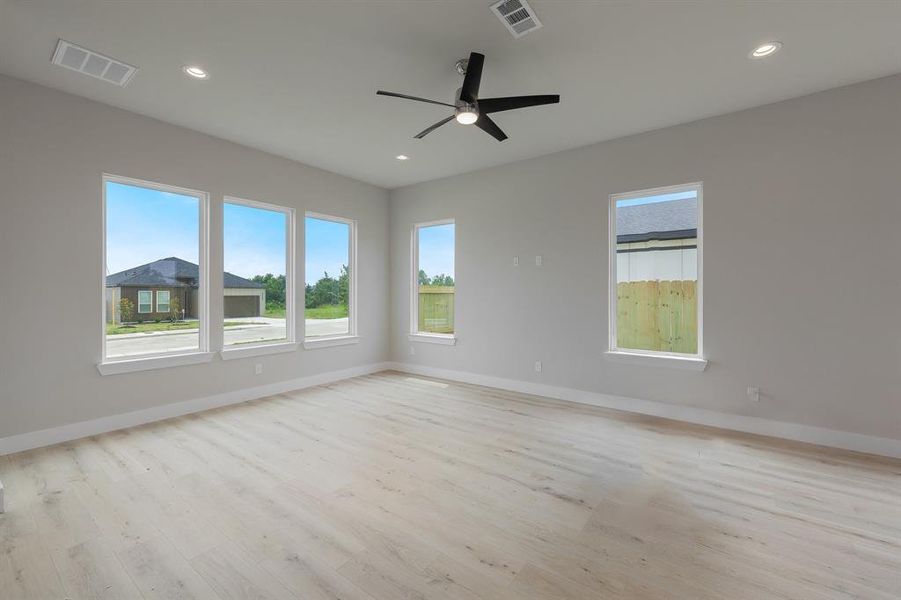 Spare room featuring light wood-type flooring, a ceiling fan, baseboards, and recessed lighting
