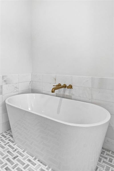 Bathroom featuring tile walls and a tub to relax in