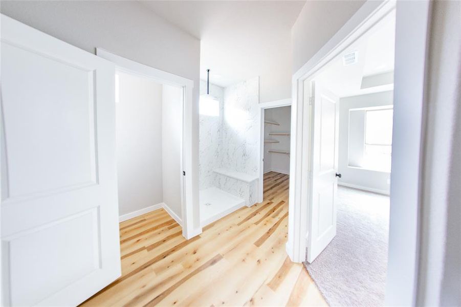 Hall with healthy amount of natural light and light wood-style flooring
