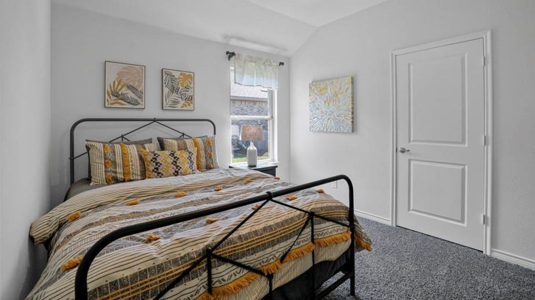 Carpeted bedroom featuring vaulted ceiling and baseboards
