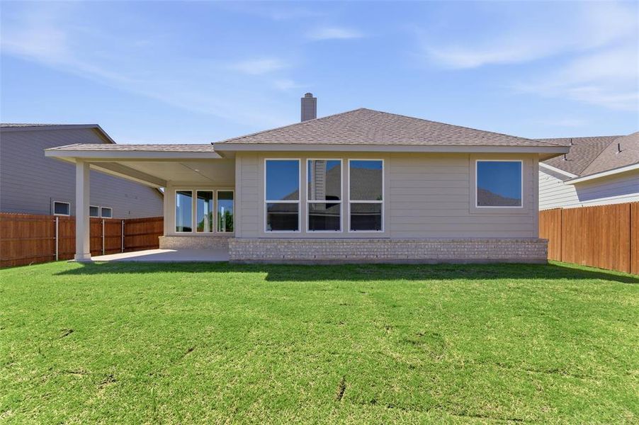Rear view of house featuring a fenced backyard, a patio area, a shingled roof, and a chimney