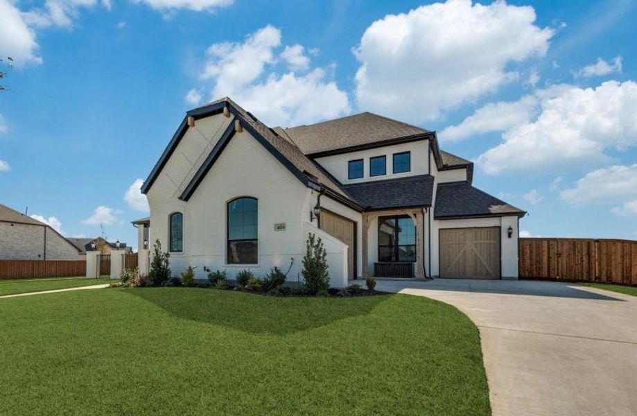 View of front facade featuring a garage and a front lawn