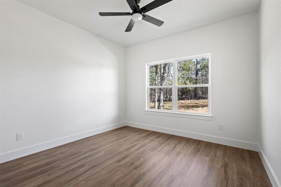 Empty room featuring hardwood / wood-style flooring and ceiling fan