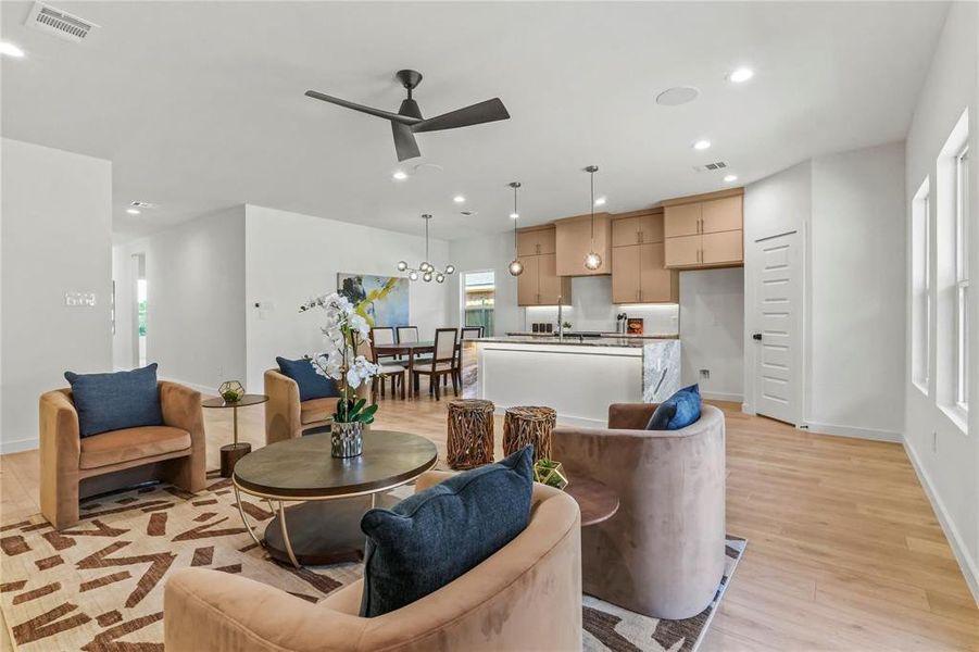 Living room featuring recessed lighting, ceiling fan, and light wood-type flooring Living room featuring recessed lighting, ceiling fan, and light wood-type flooring