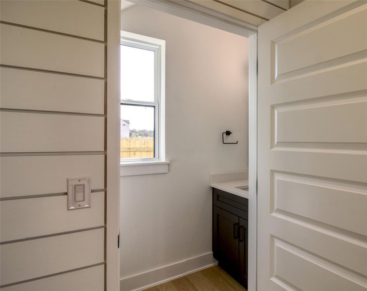 Powder room with vanity and light wood-style flooring Powder room with vanity and light wood-style flooring