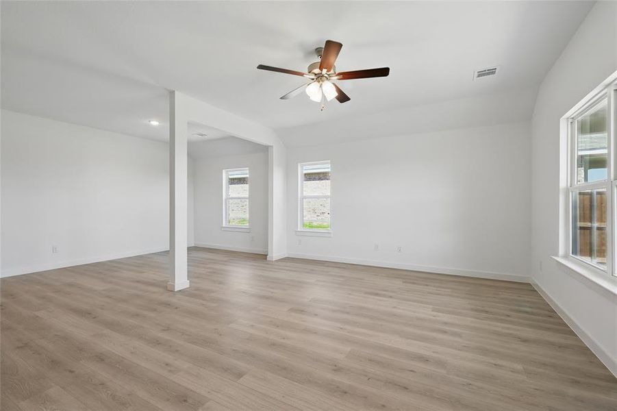 Empty room featuring visible vents, light wood-type flooring, baseboards, and ceiling fan Empty room featuring visible vents, light wood-type flooring, baseboards, and ceiling fan