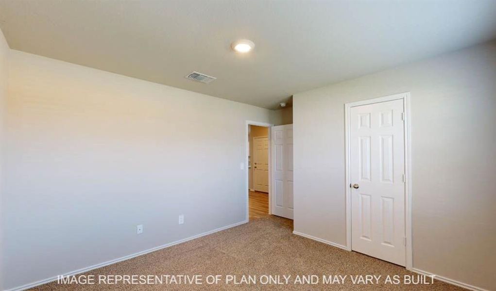 Carpeted room featuring light-toned walls, a white paneled door, and recessed lighting Carpeted room featuring light-toned walls, a white paneled door, and recessed lighting