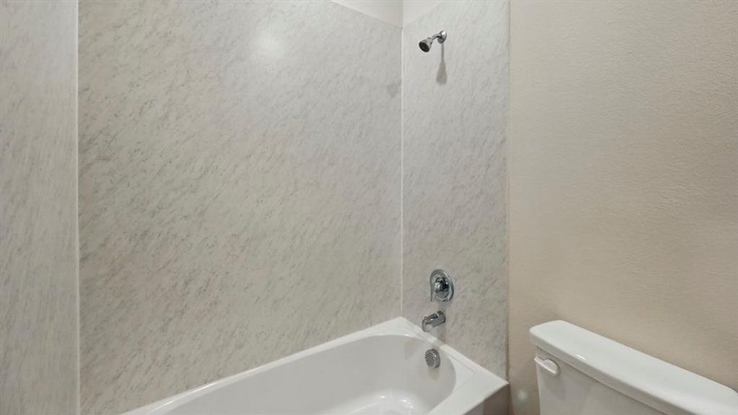 Full bathroom featuring washtub / shower combination and toilet