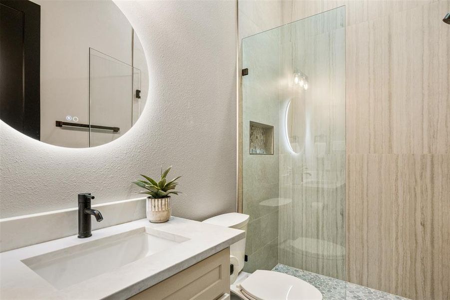 Second Full Bath with floor to ceiling tile, marble shower floor, shampoo niche and led mirror