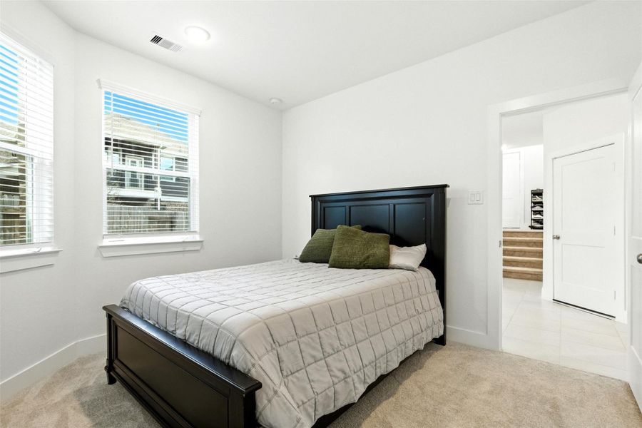 The first floor bedroom features largewindows and plush carpet. The first floor bedroom features largewindows and plush carpet.