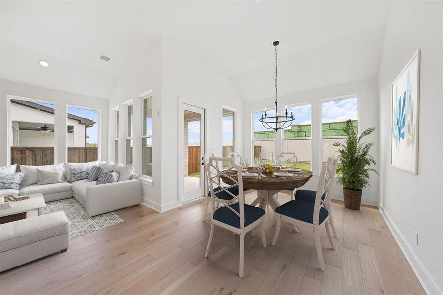 Sunroom / solarium with hardwood / wood-style floors, lofted ceiling, and a chandelier Sunroom / solarium with hardwood / wood-style floors, lofted ceiling, and a chandelier
