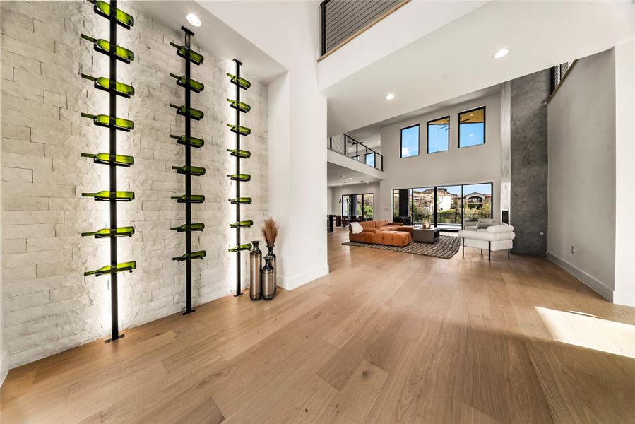 Wine cellar featuring a high ceiling, light wood-type flooring, and recessed lighting Wine cellar featuring a high ceiling, light wood-type flooring, and recessed lighting