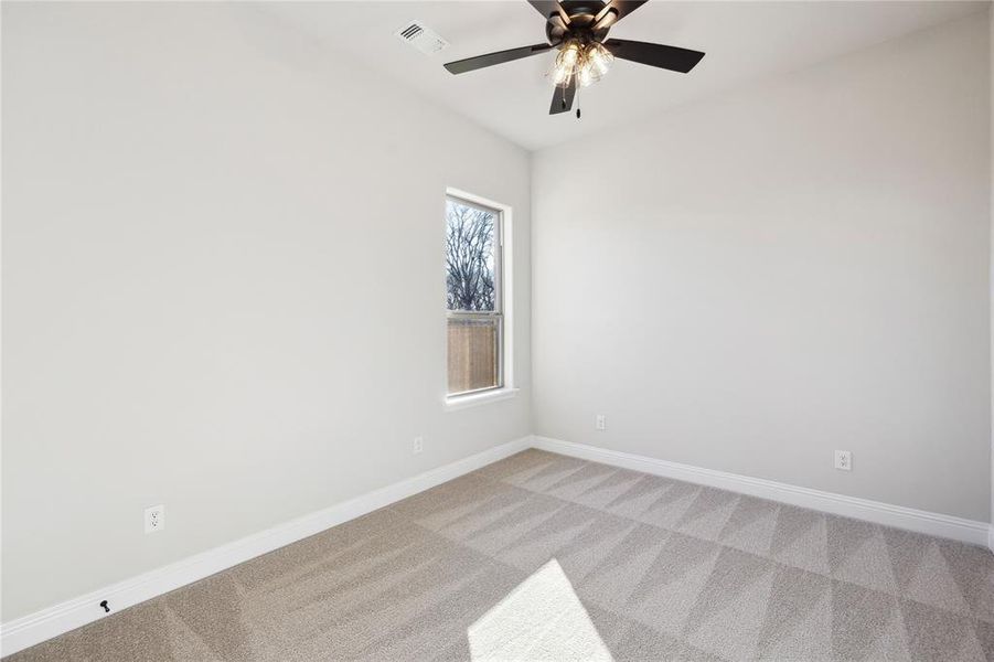 Carpeted empty room with ceiling fan