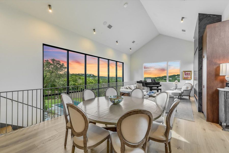 Dining area featuring high vaulted ceiling and light wood finished floors