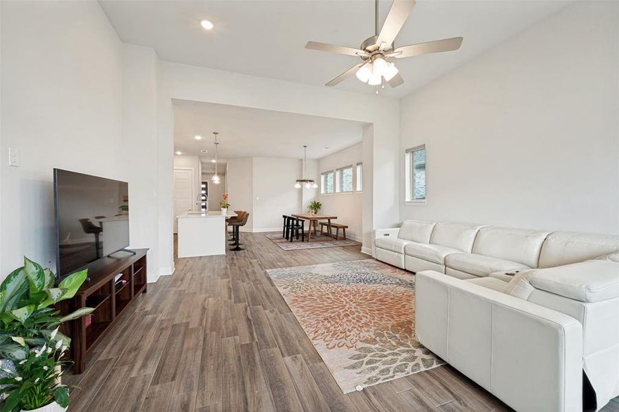 Spacious living area featuring wood-finish flooring, recessed lighting, and a ceiling fan
