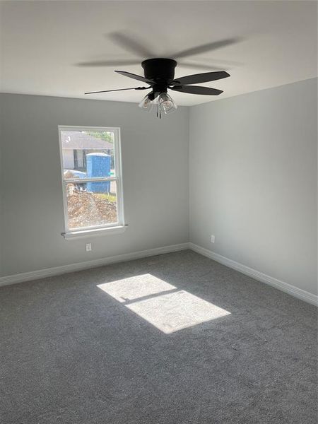 Carpeted empty room with ceiling fan