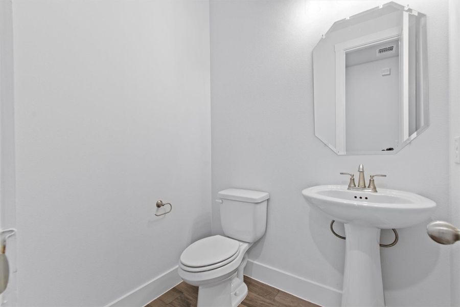 Bathroom with hardwood / wood-style flooring, sink, and toilet