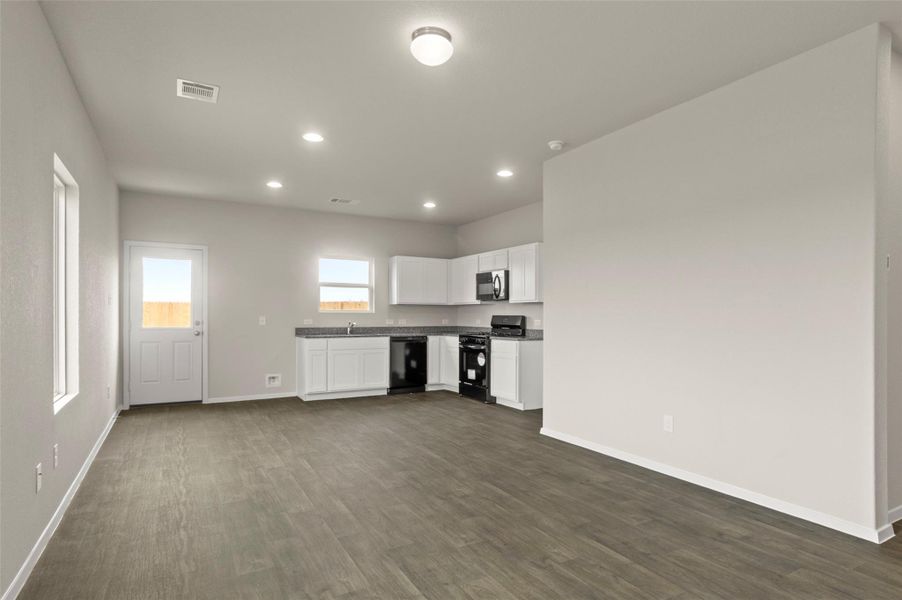 Kitchen featuring dark wood-style floors, black appliances, white cabinets, recessed lighting, and dark countertops