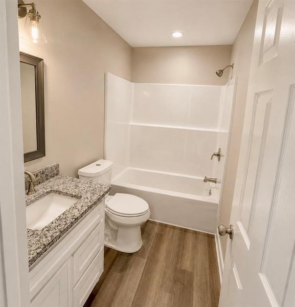 Contemporary bathroom featuring a white vanity with a speckled countertop, a rectangular undermount sink, and brushed nickel fixtures Contemporary bathroom featuring a white vanity with a speckled countertop, a rectangular undermount sink, and brushed nickel fixtures