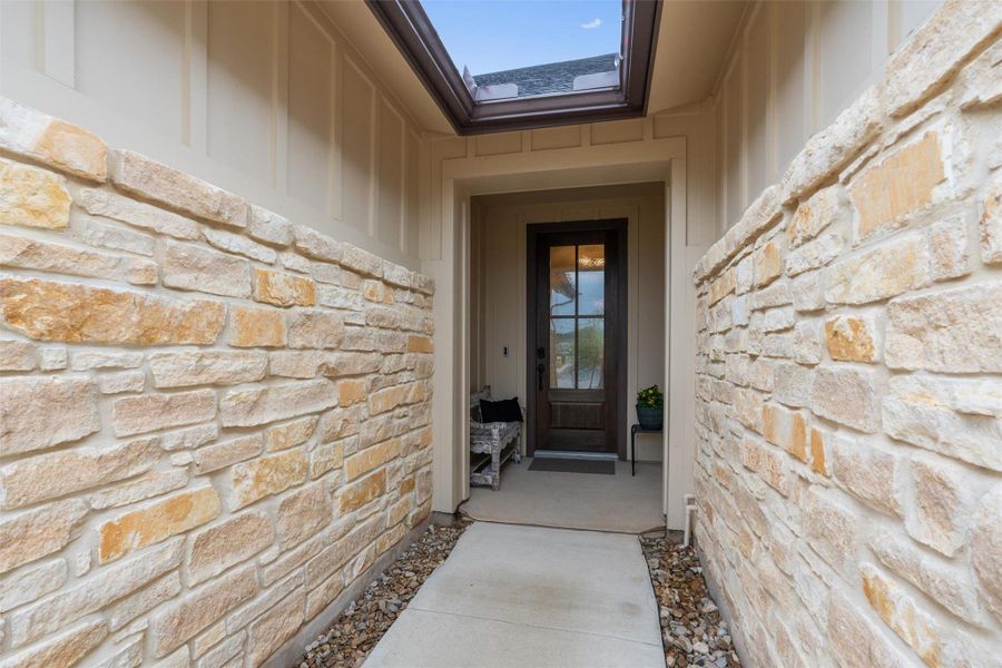 The entry to the front door features stone & Hardie plank siding and a seating area to each side of the wood & glass front door. The entry to the front door features stone & Hardie plank siding and a seating area to each side of the wood & glass front door.