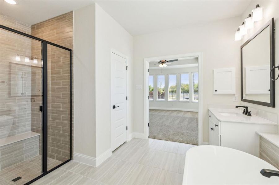 Bathroom with vanity, plus walk in shower, tile patterned flooring, and ceiling fan