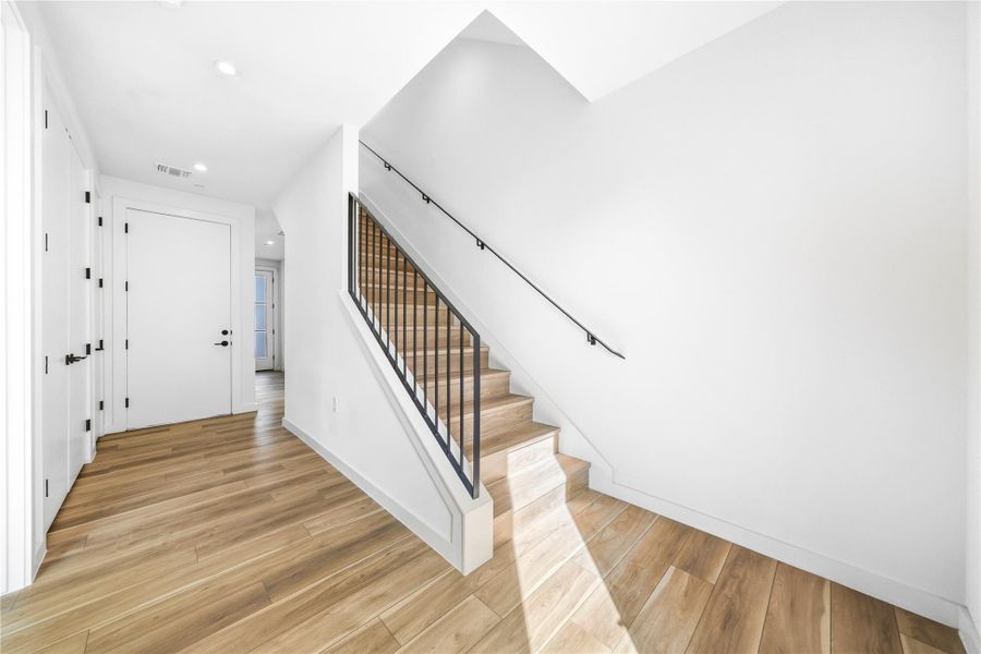 Entrance foyer with stairway, recessed lighting, and light wood-type flooring