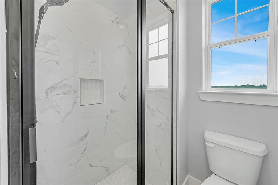 Bathroom with toilet and a marble finish shower