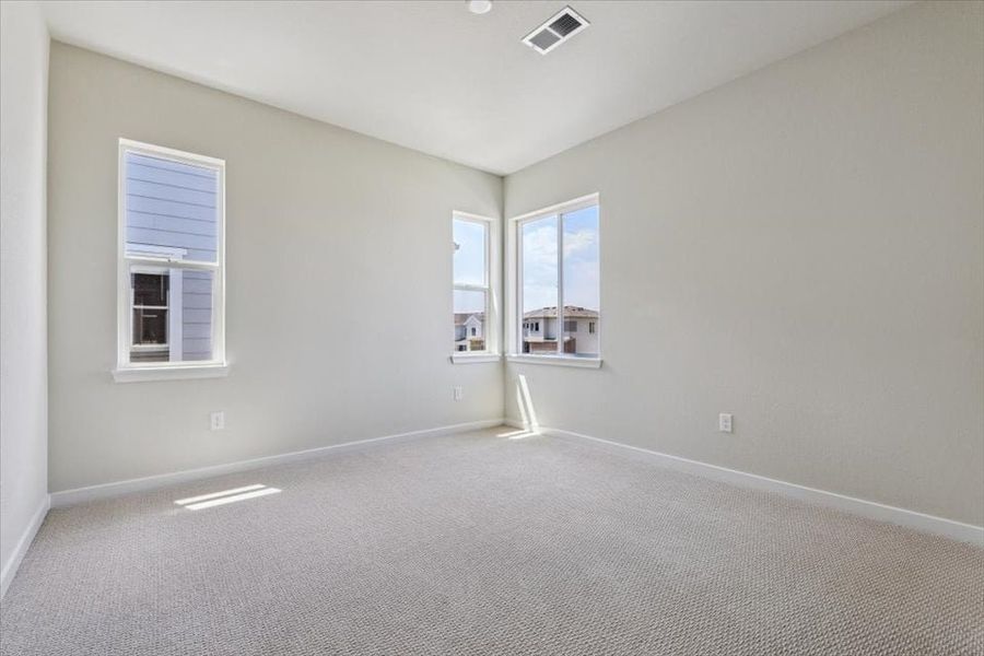 A room with a white carpet and windows.