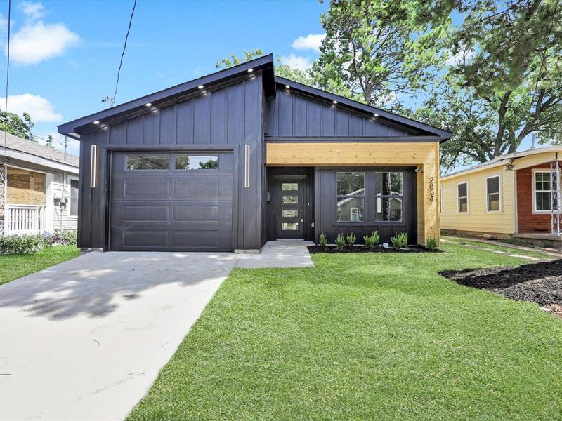 View of front of home featuring a garage and a front lawn