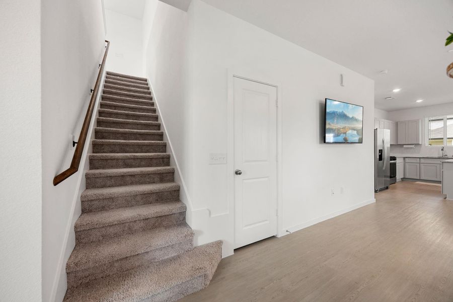 The staircase leads to a spacious second level, creating a functional separation between entertaining spaces downstairs and private living areas upstairs.
