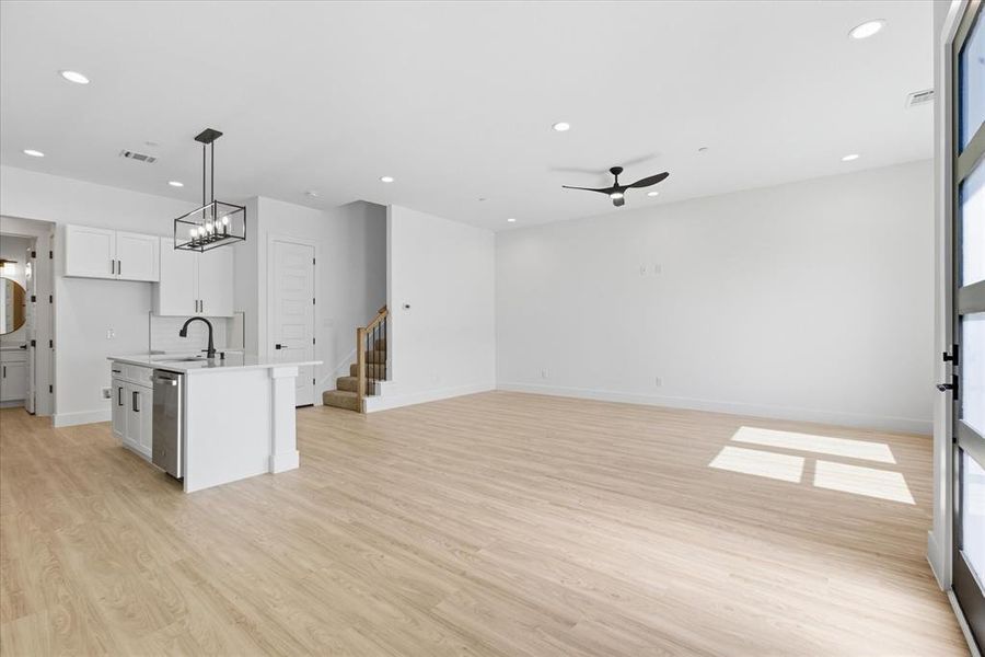 Kitchen with hanging light fixtures, light wood-type flooring, white cabinetry, recessed lighting, and a chandelier
