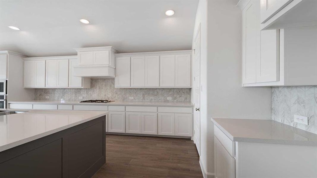 Kitchen with decorative backsplash, dark hardwood / wood-style floors, and white cabinets