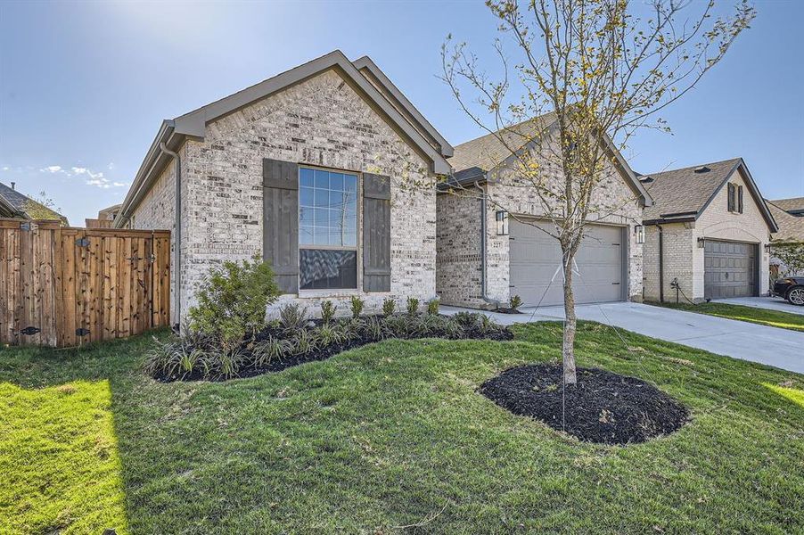 View of front facade featuring a front lawn and a garage