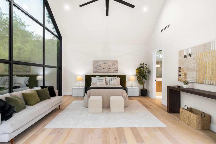 Vaulted ceiling interior featuring a floor-to-ceiling multi-pane window, light wood-finish flooring, recessed lighting, and a ceiling fan