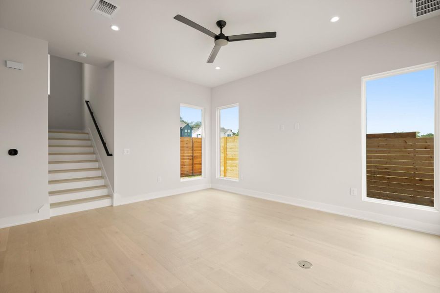 Spare room featuring stairs, light wood finished floors, recessed lighting, and ceiling fan Spare room featuring stairs, light wood finished floors, recessed lighting, and ceiling fan