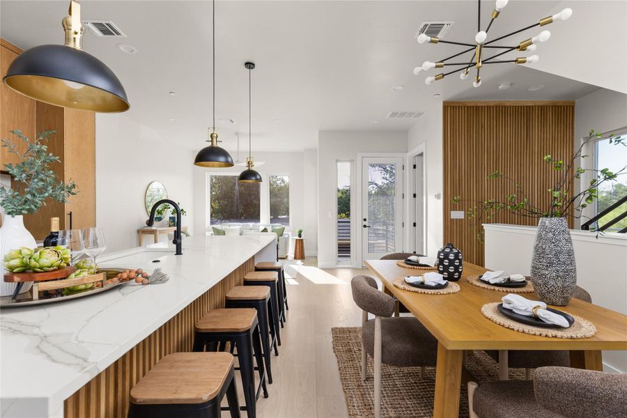 Clean lines and a spacious kitchen island anchor this open-concept culinary and dining area.