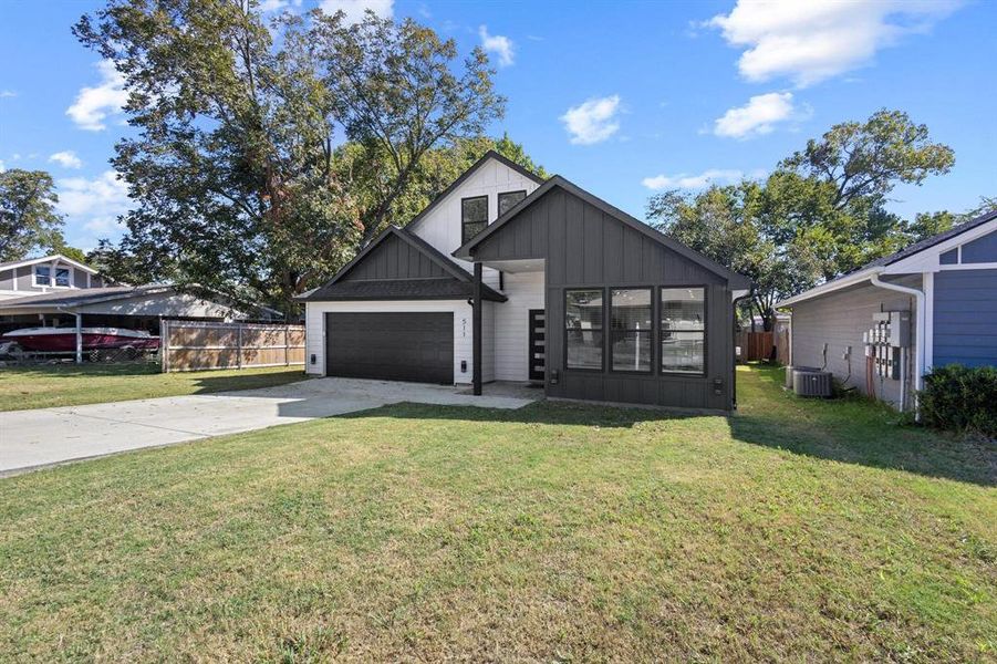 Modern inspired farmhouse featuring board and batten siding, concrete driveway, and an attached garage