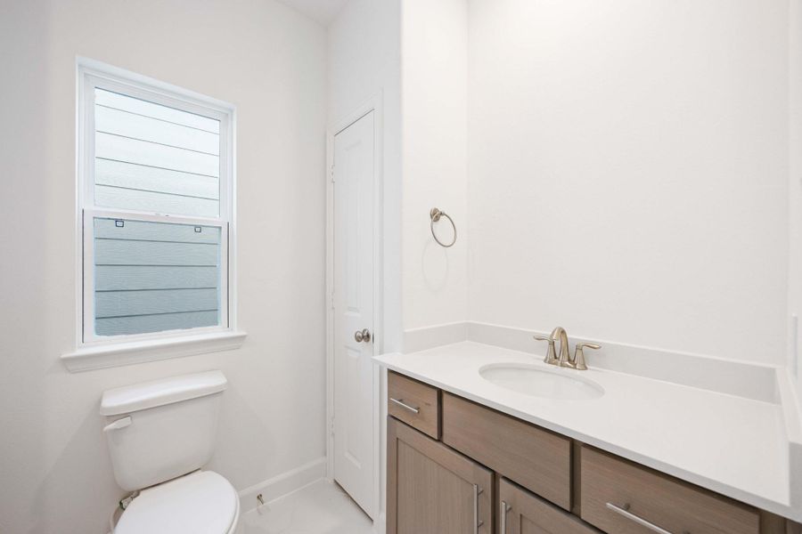 Secondary full bath with modern finishes and smart storage.