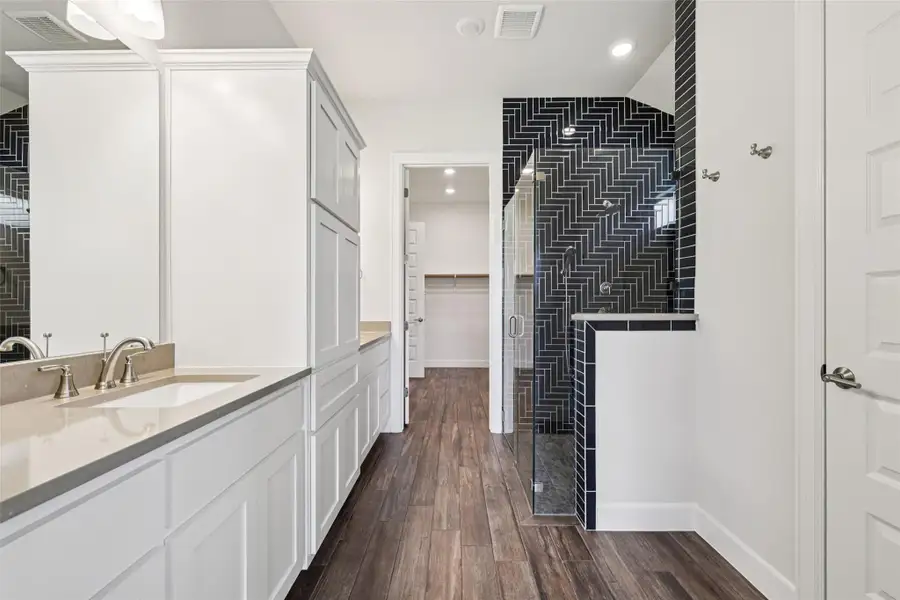 Full bath featuring a stall shower, vanity, tile walls, wood finished floors, and recessed lighting