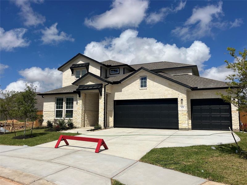 Front exterior of a new home in Sunterra, Katy, TX, highlighting curb appeal (Image 18).