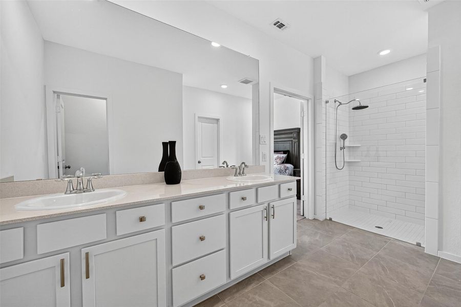 Spacious primary bathroom featuring a double vanity, elegant fixtures, and a sleek walk-in shower. Spacious primary bathroom featuring a double vanity, elegant fixtures, and a sleek walk-in shower.