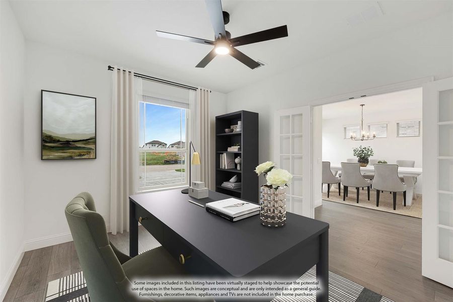 Home office with dark desk, ceiling fan, hardwood floors, and French doors opening to dining room