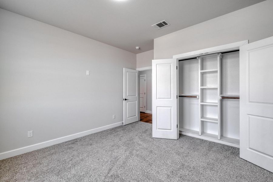 Unfurnished bedroom with carpet floors, baseboards, and a closet