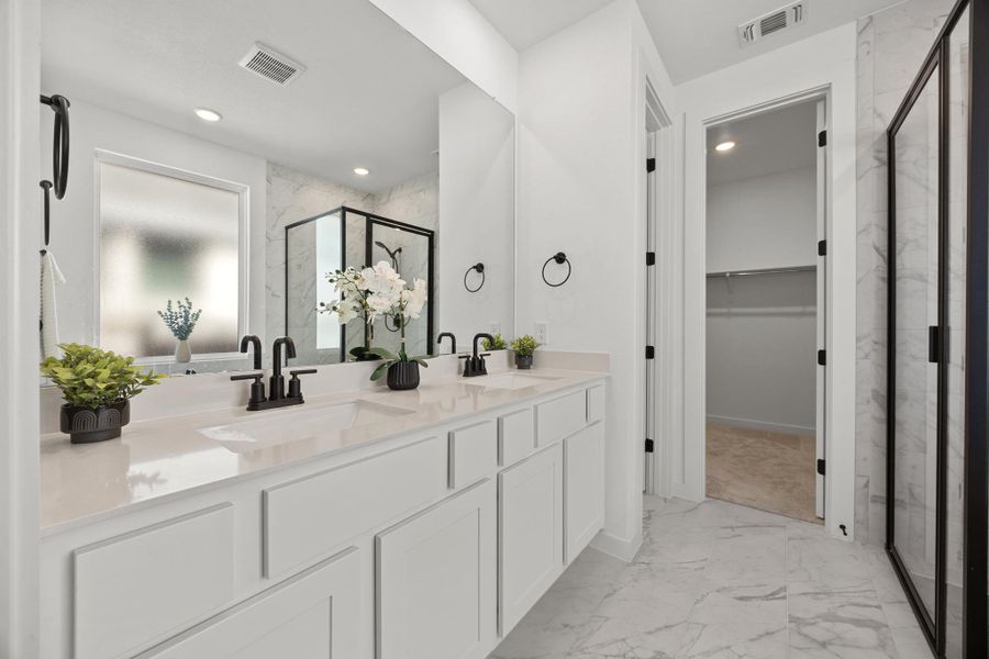 Bathroom with light marble finish floors, double vanity, a marble finish shower, a walk in closet, and recessed lighting