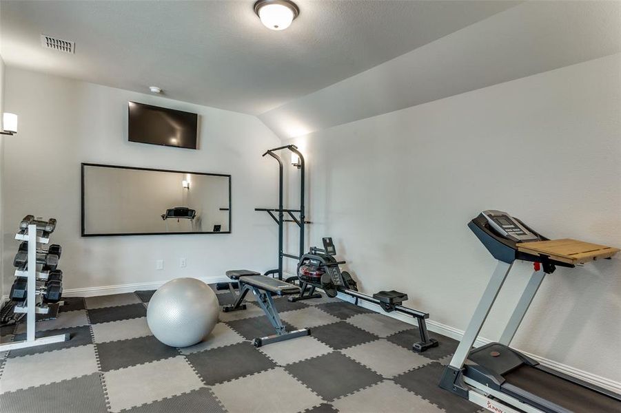 Workout area with lofted ceiling and baseboards Workout area with lofted ceiling and baseboards