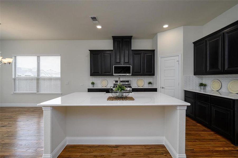 Kitchen with a kitchen island, decorative backsplash, and dark hardwood / wood-style flooring