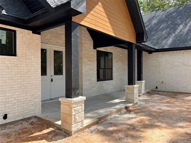 Generous front porch with stone and cedar columns and beamed ceiling leads to double-entry front door. Generous front porch with stone and cedar columns and beamed ceiling leads to double-entry front door.